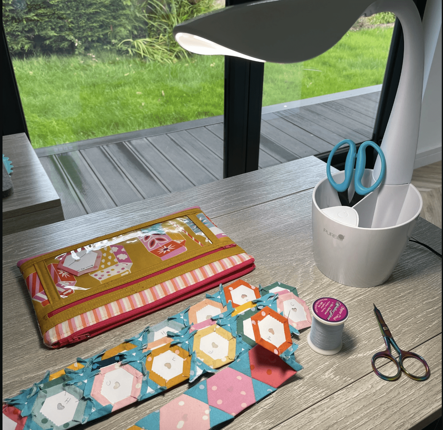 table with quilting supplies and lamp