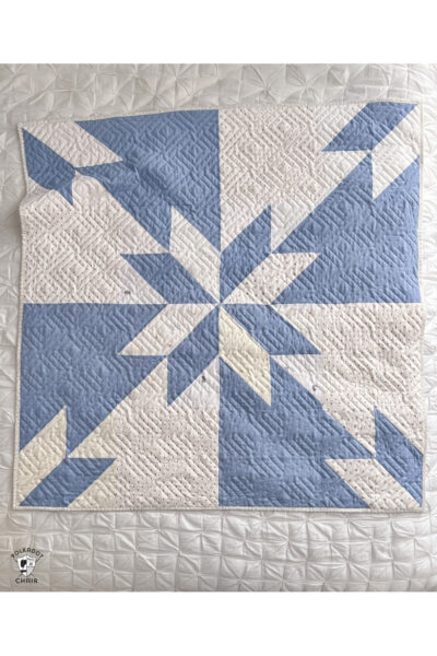 Blue and white baby quilt on white quilt