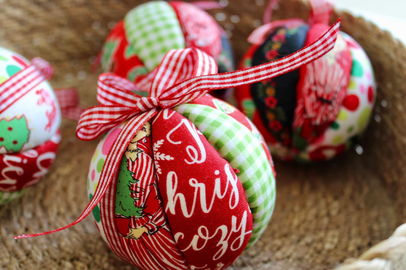 red, white and green fabric christmas ornament with bow in basket