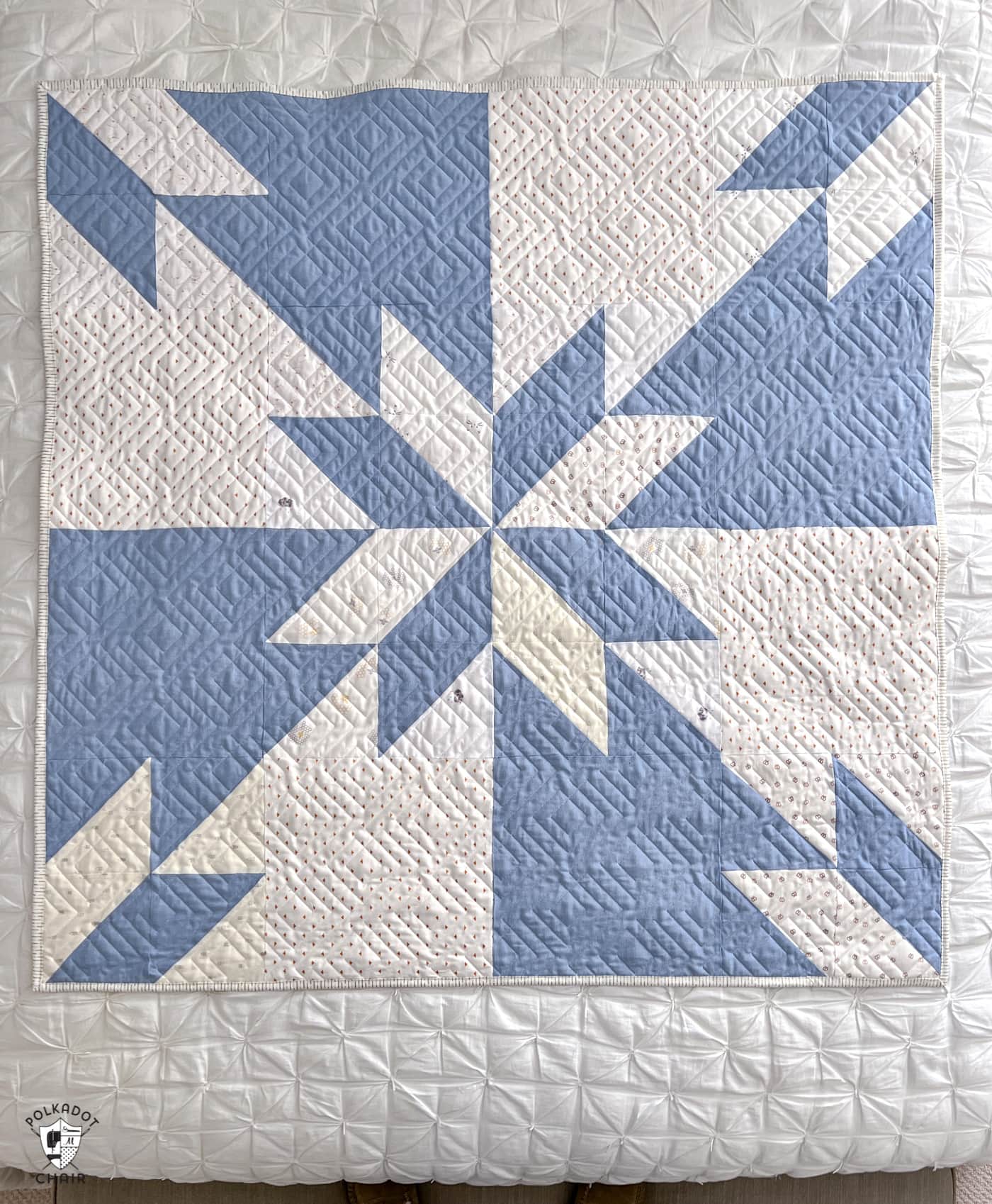 blue and white star baby quilt on bed