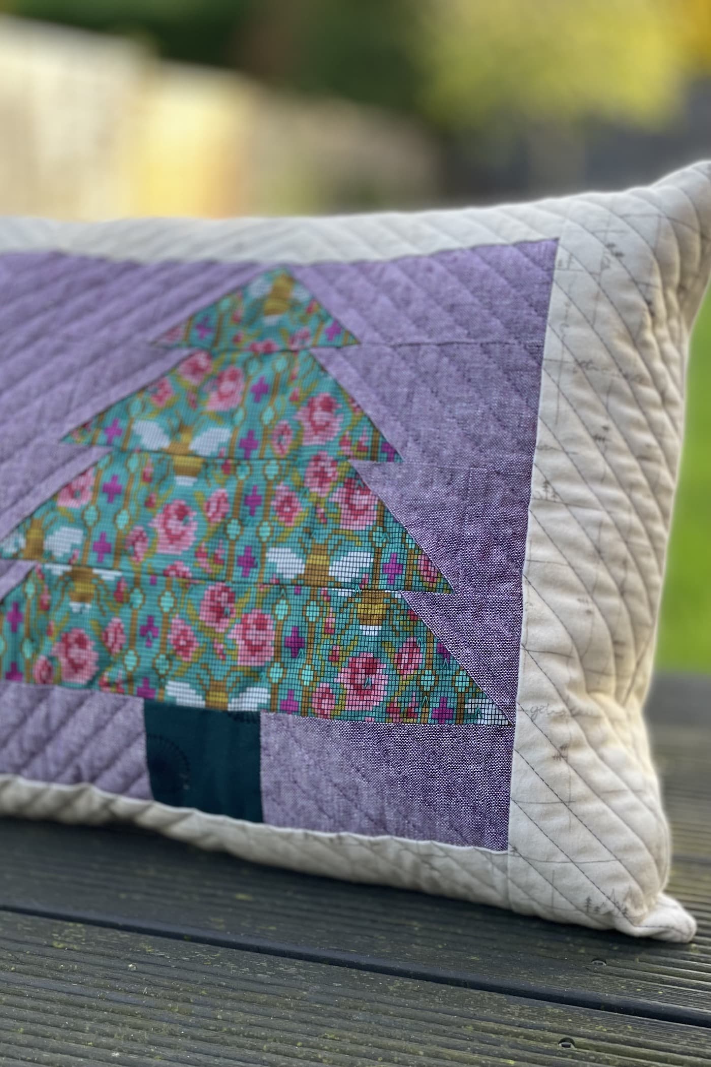 Purple and green pillow with patchwork pieced evergreen trees outdoors