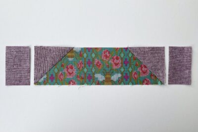 purple and green fabric on white tabletop cut into squares and triangles