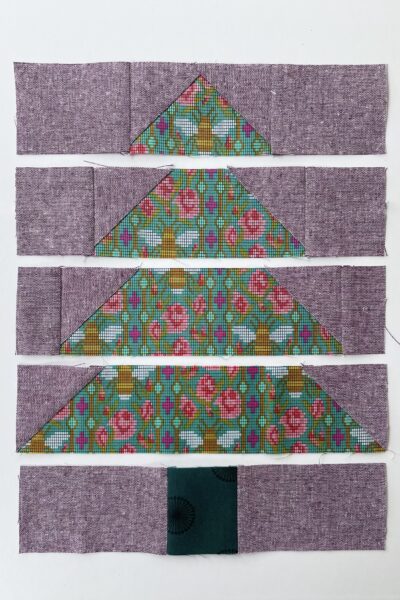purple and green fabric on white tabletop cut into squares and triangles