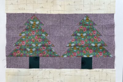 purple and green fabric on white tabletop cut into squares and triangles