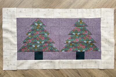 purple and green fabric on white tabletop cut into squares and triangles