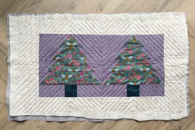 purple and green fabric on white tabletop cut into squares and triangles