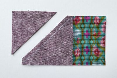 purple and green fabric on white tabletop cut into squares and triangles