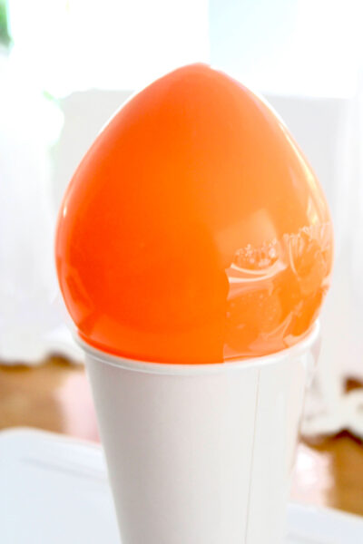 Orange balloon and white cup on table