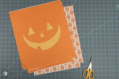 orange fabric pieces on blue cutting mat