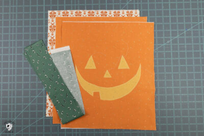 orange fabric pieces on blue cutting mat