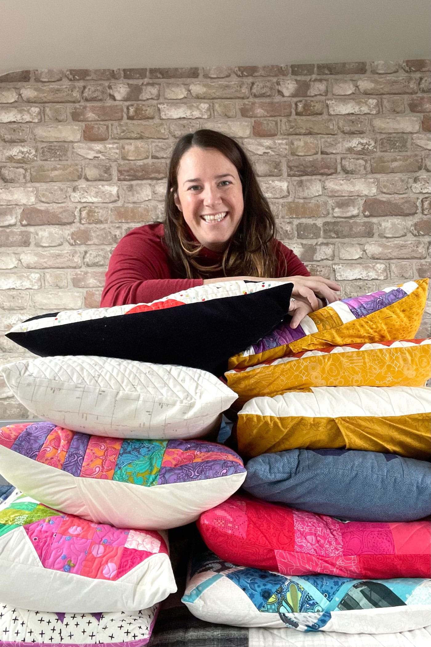 woman in front of stack of quilted pillows