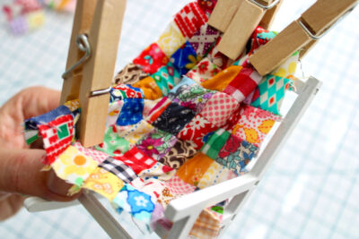 fabric scraps sewn into mini quilt with clothespins