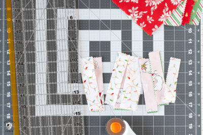 fabric scraps on gray cutting mat with ruler and rotary cutter