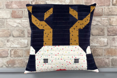 quilted reindeer pillow on bed