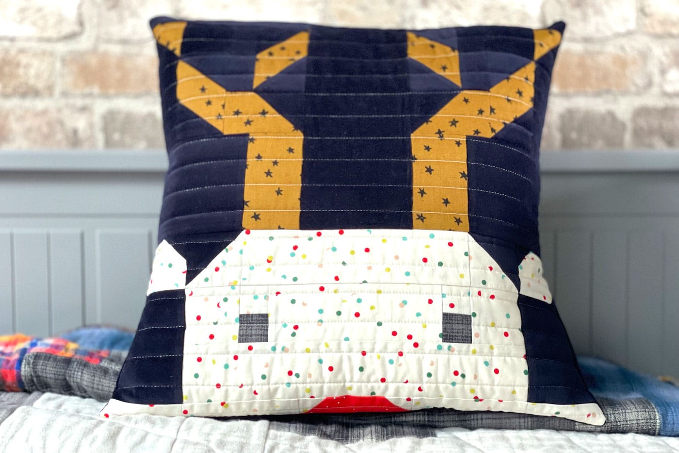 quilted reindeer pillow on bed