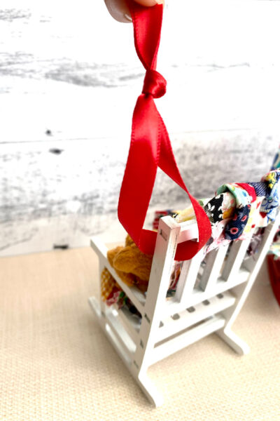 close up of white rocking chair with red ribbon