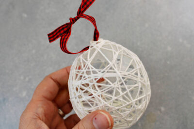 hand holding string ornament