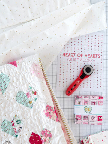 quilt and quilt supplies on white cutting mat