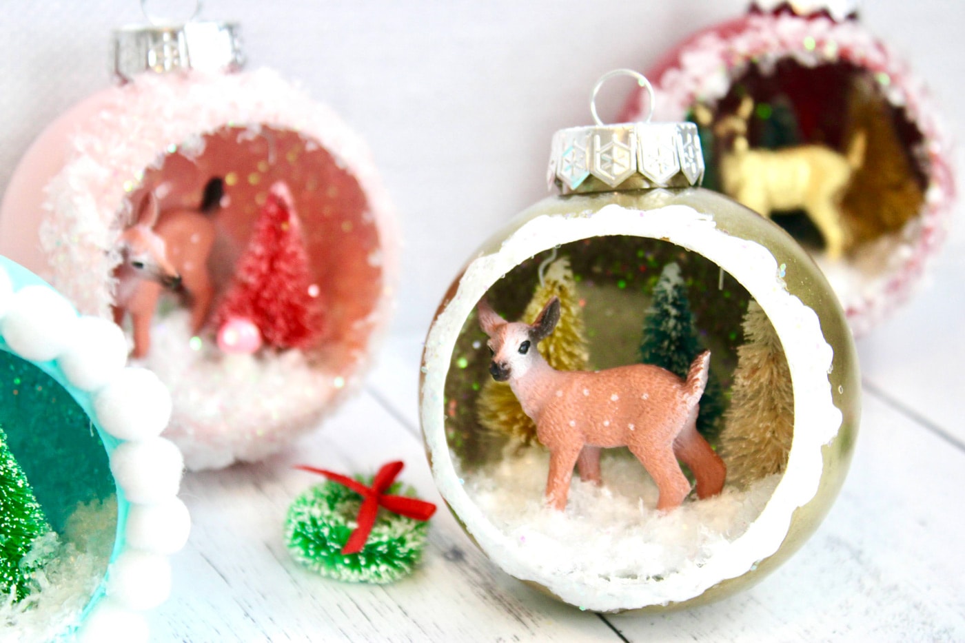 retro ornaments with deer, trees and glitter snow on white wood table