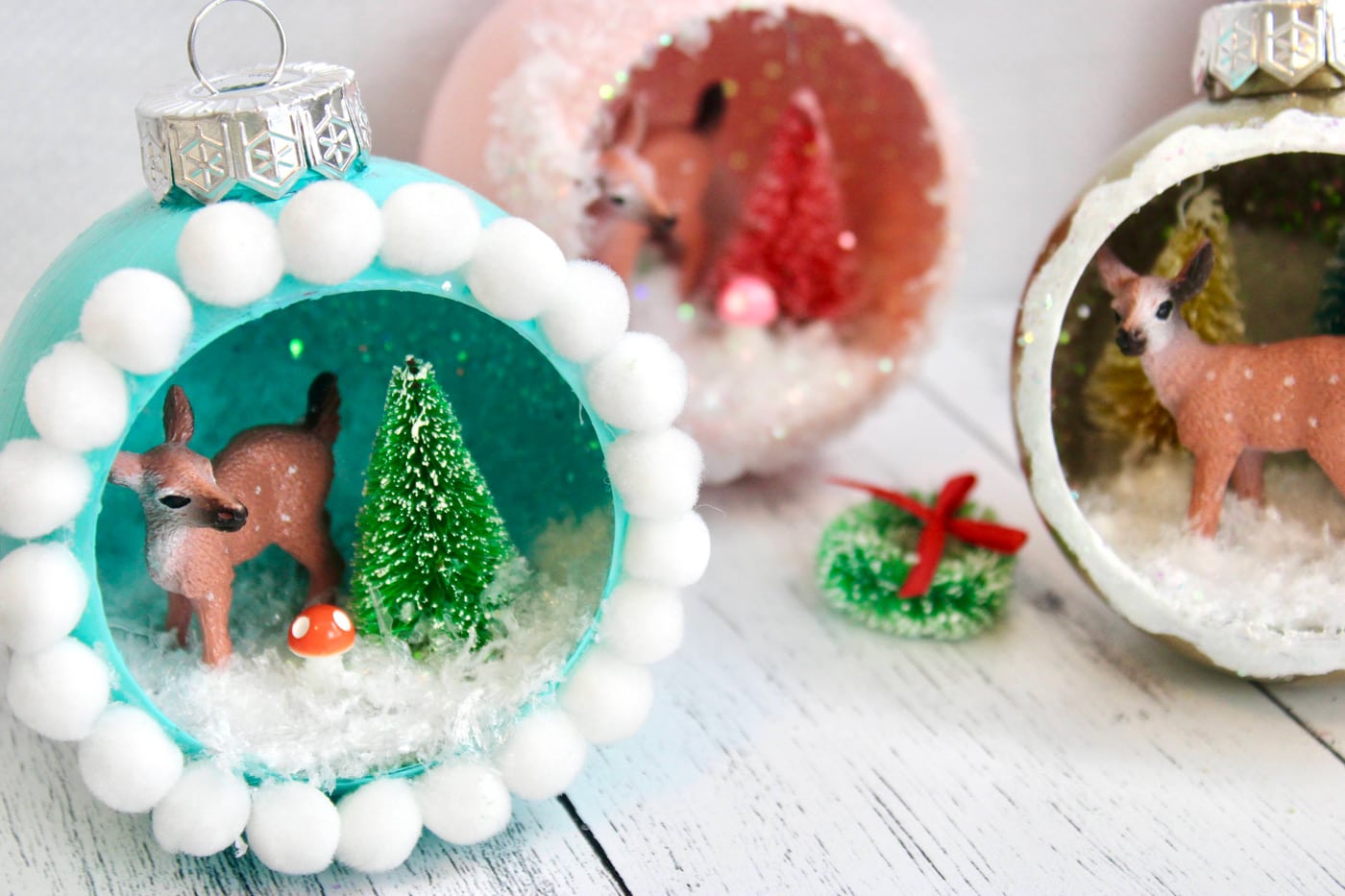 retro ornaments with deer, trees and glitter snow on white wood table