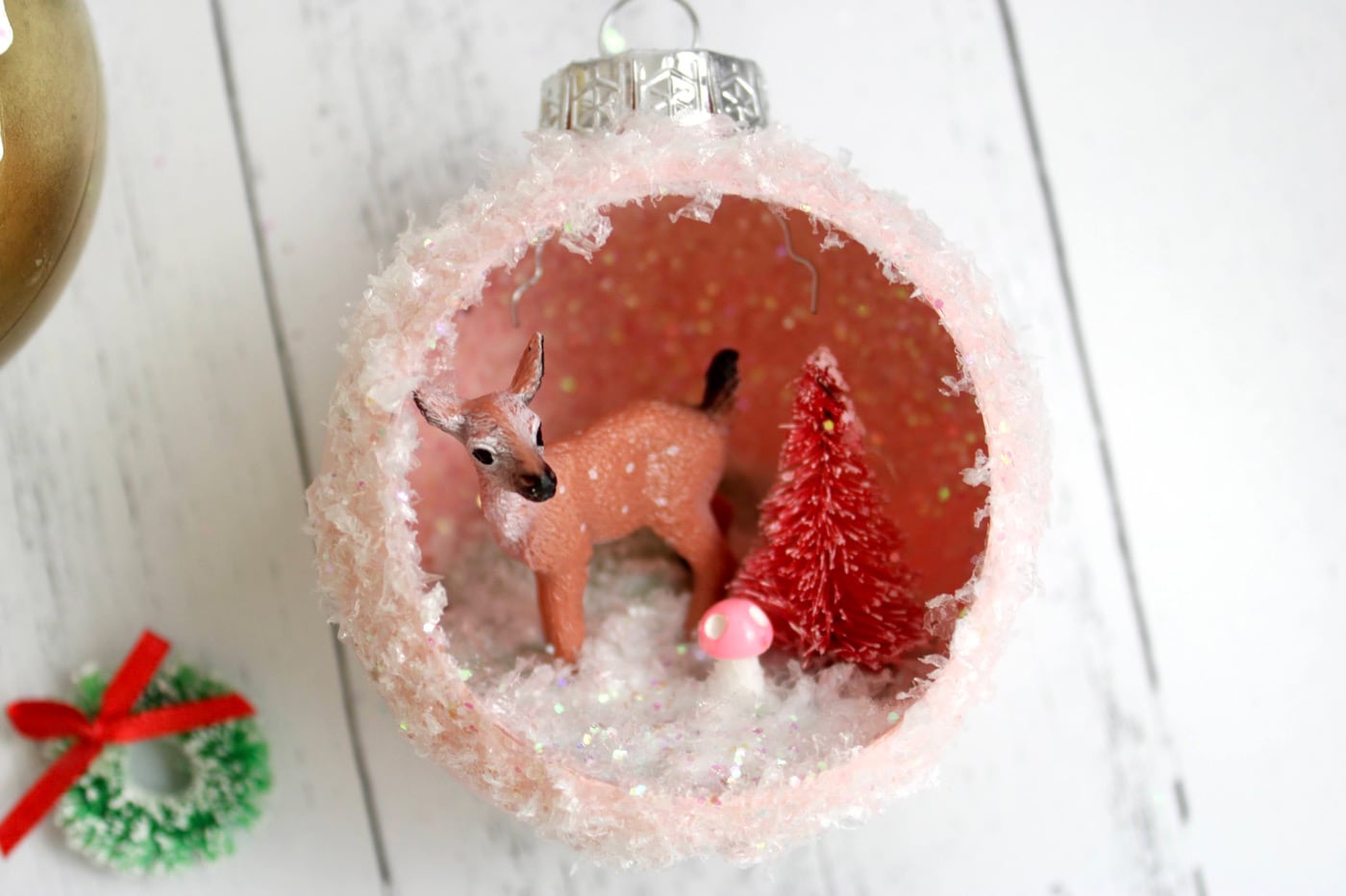 retro ornaments with deer, trees and glitter snow on white wood table