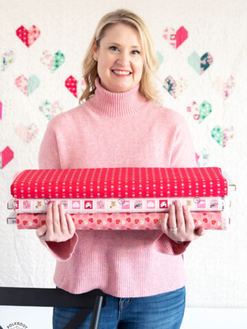 woman holding stack of valentines fabric
