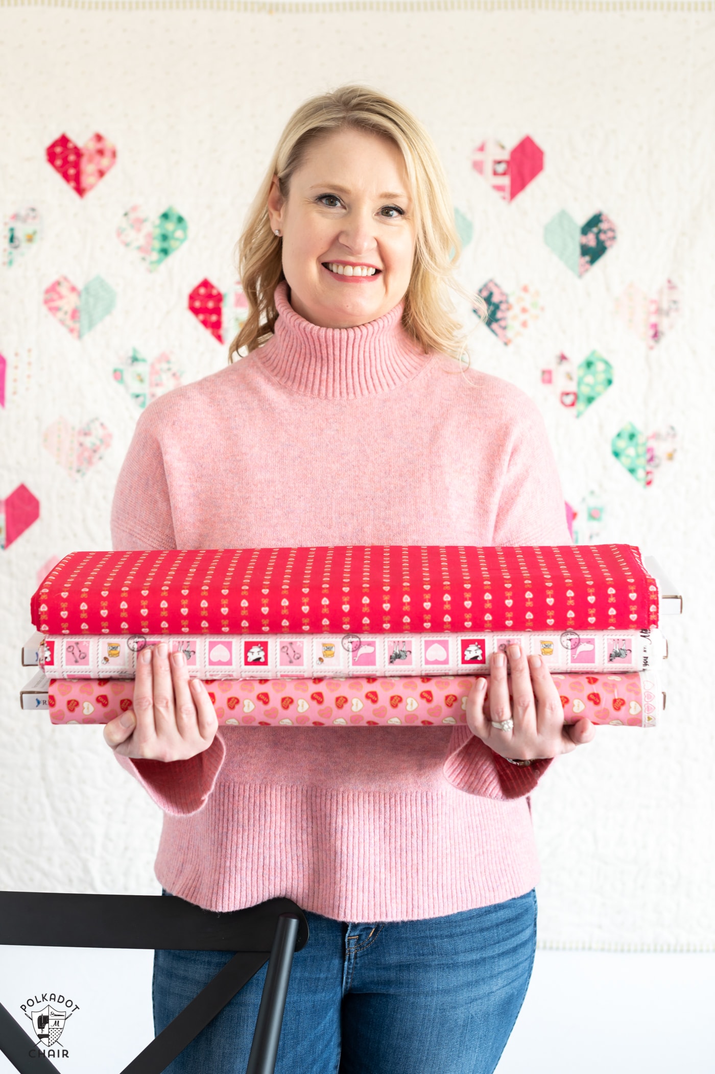 woman in pink sweater holding fabric