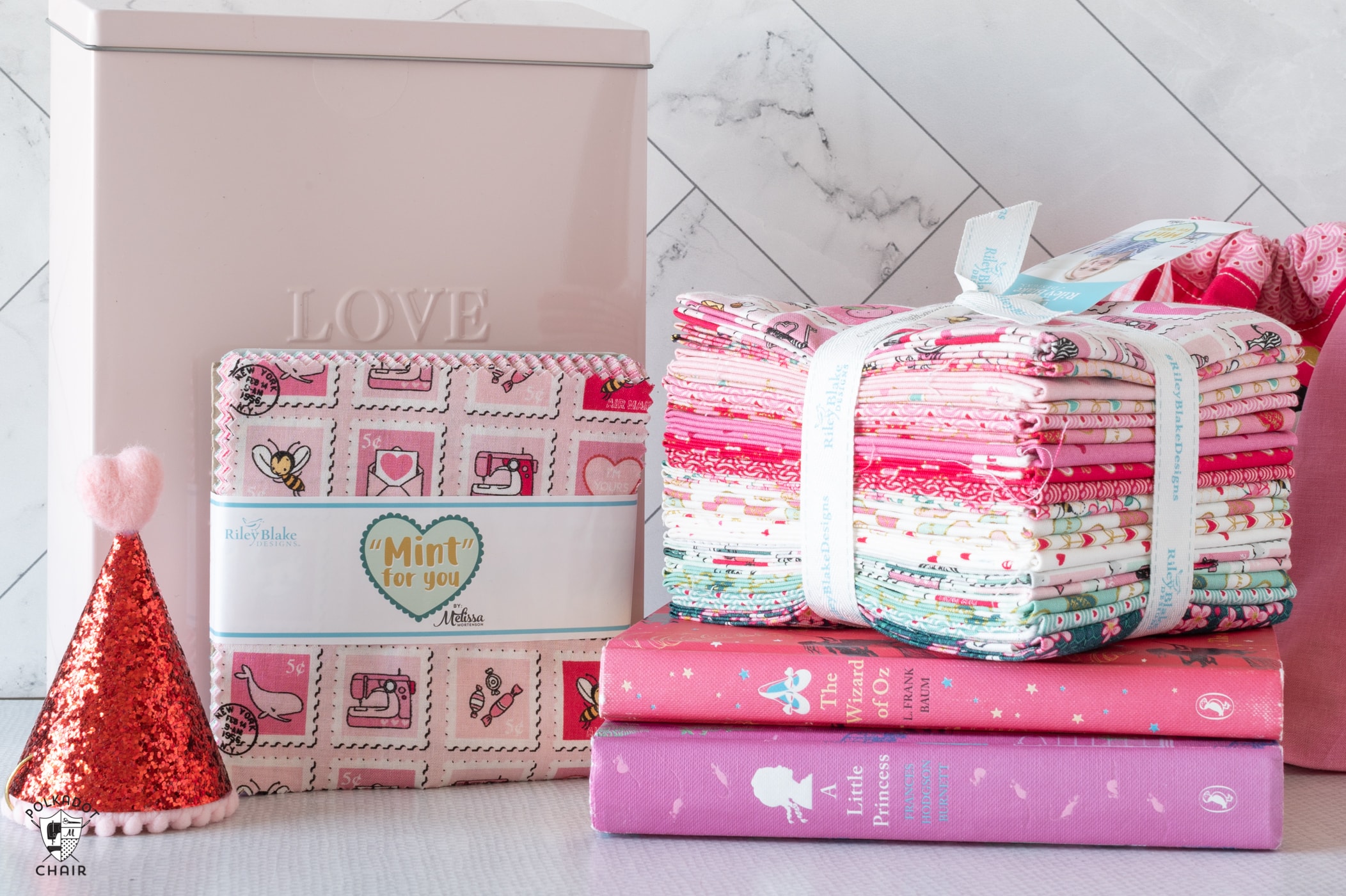 stack of fabric, books and valentine's day decorations on table