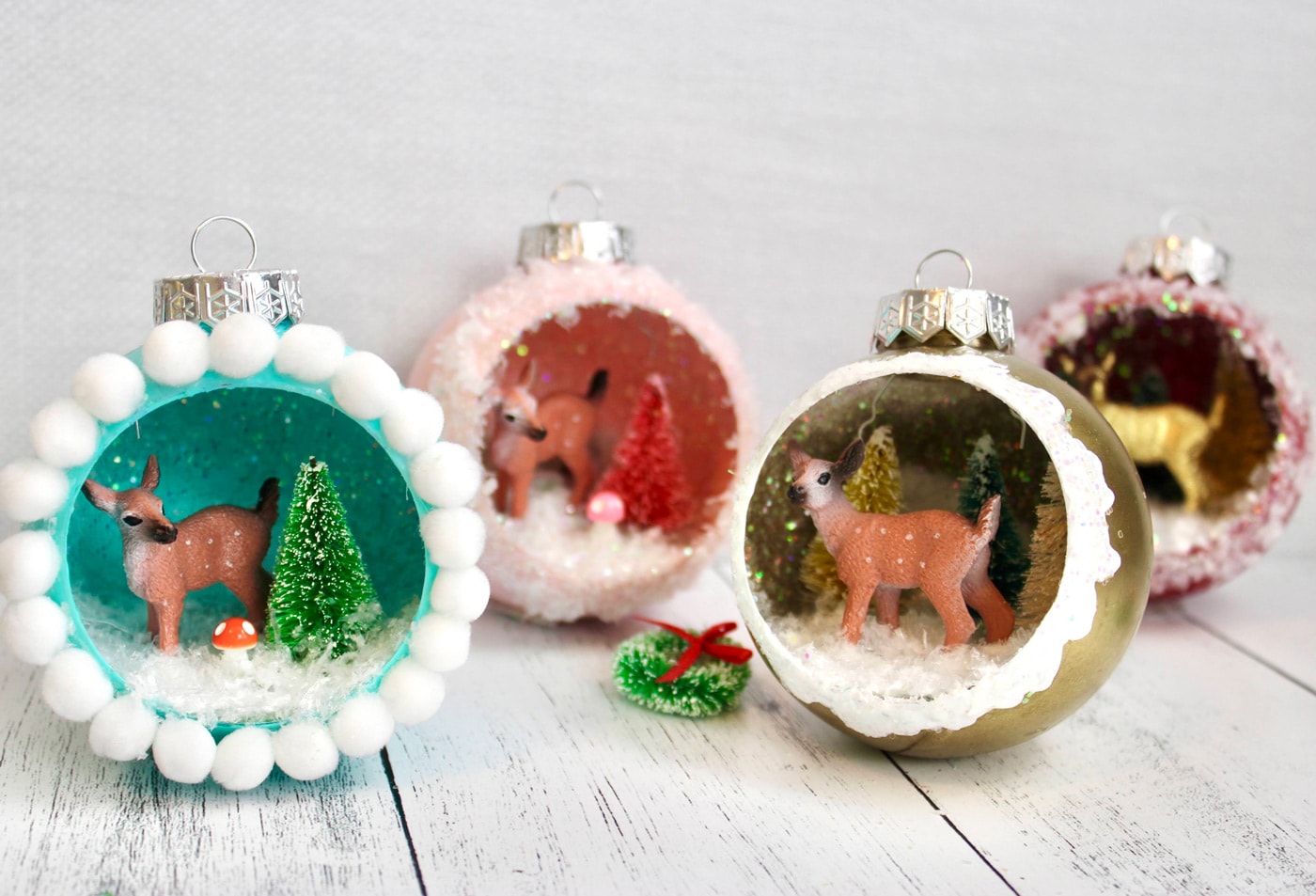 retro ornaments with deer, trees and glitter snow on white wood table
