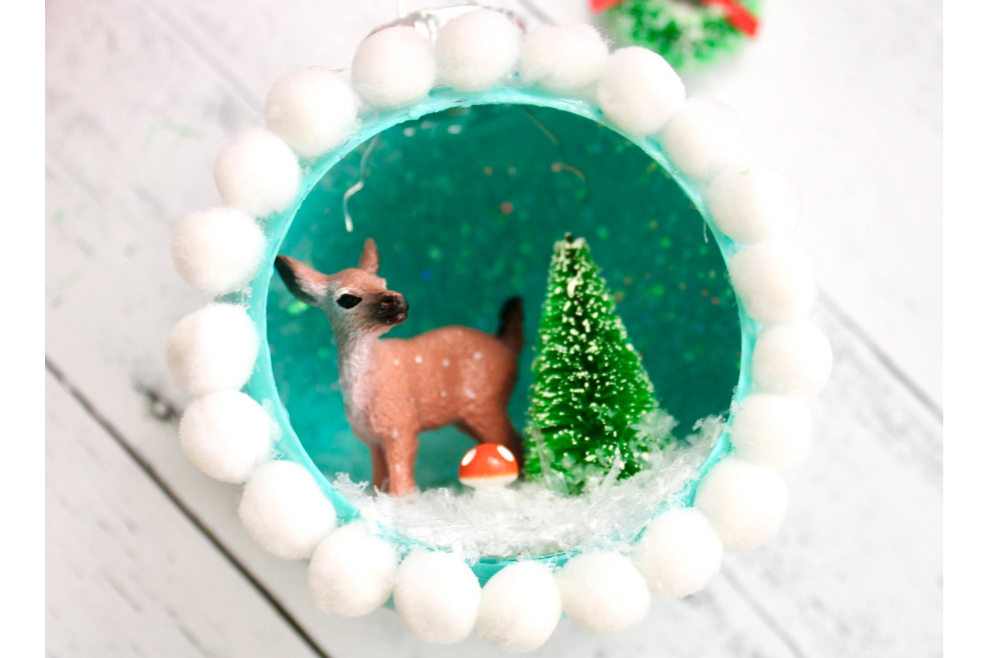 retro ornaments with deer, trees and glitter snow on white wood table