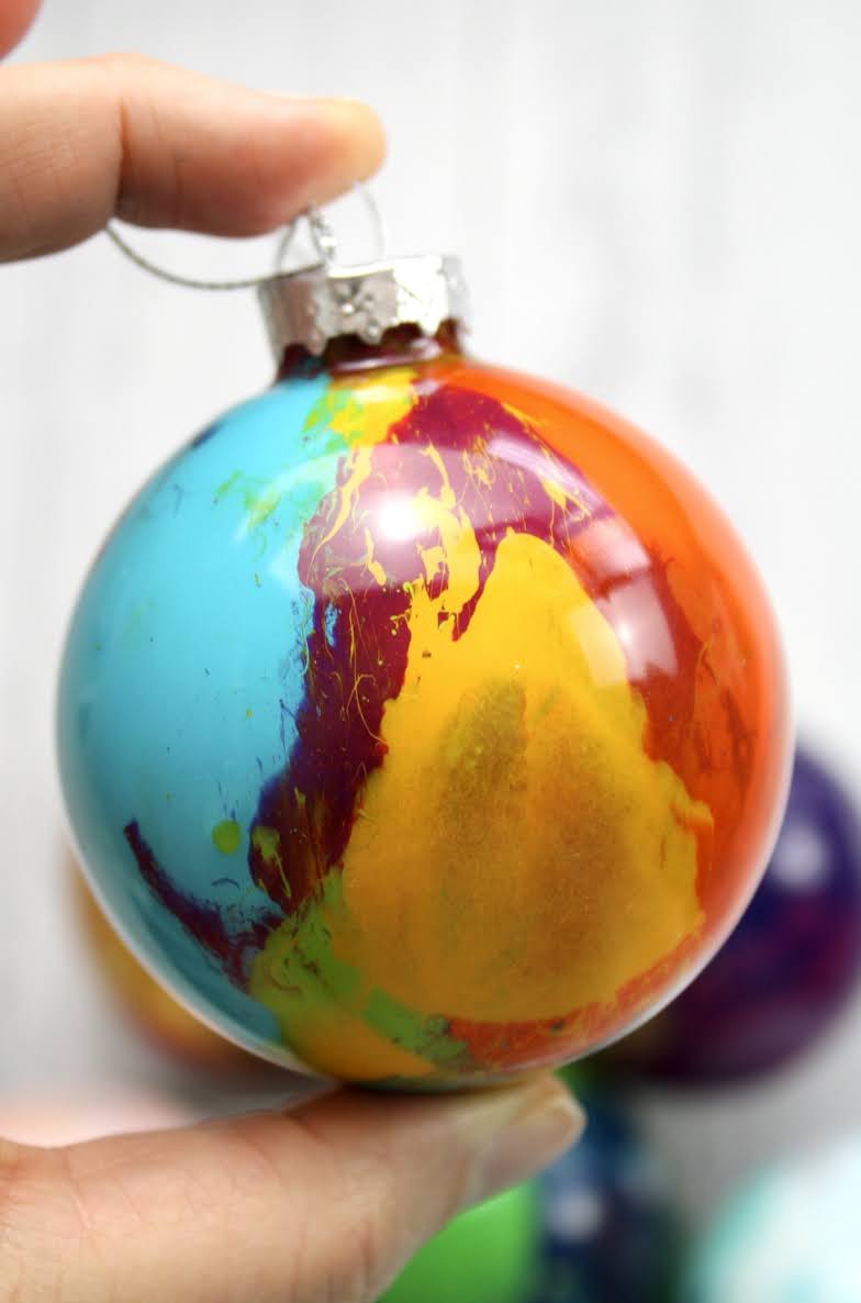 hand holding multi color splatter paint ornament