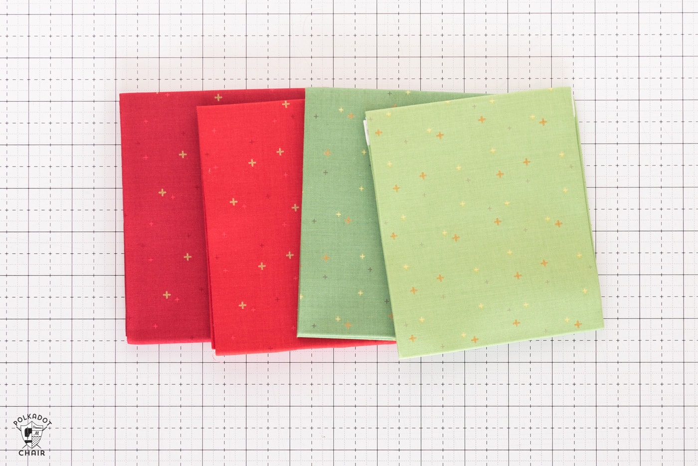 stack of colorful folded fabrics on white cutting mat