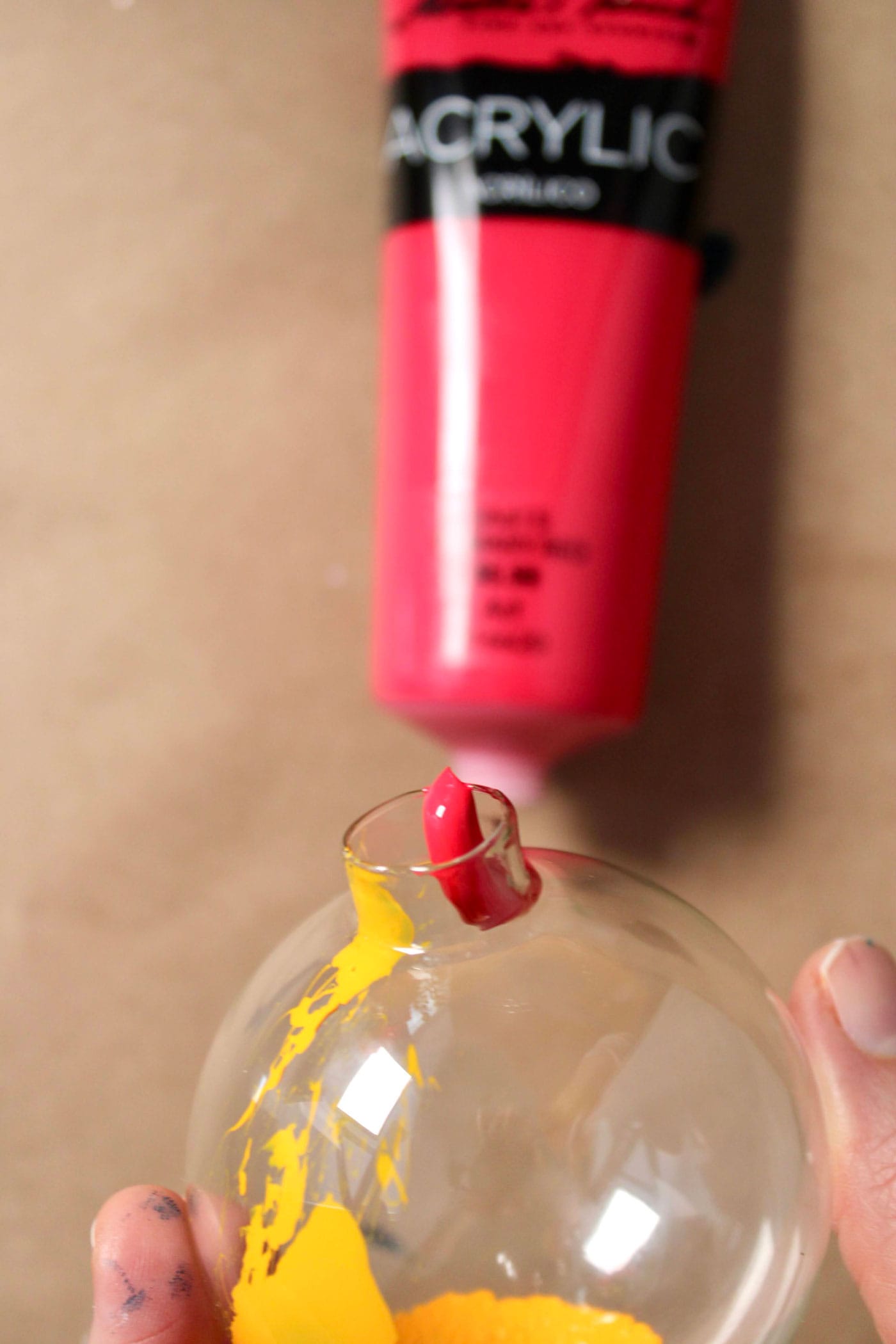 paint tube and glass ornament on brown table top