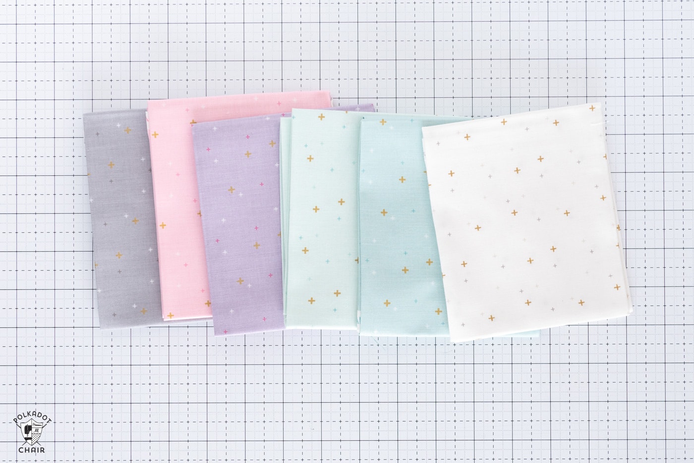 stack of colorful folded fabrics on white cutting mat