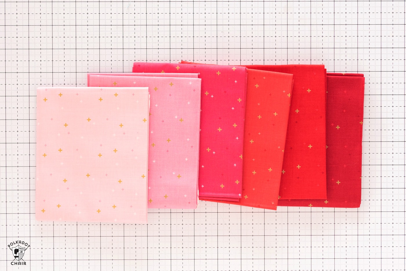 stack of colorful folded fabrics on white cutting mat