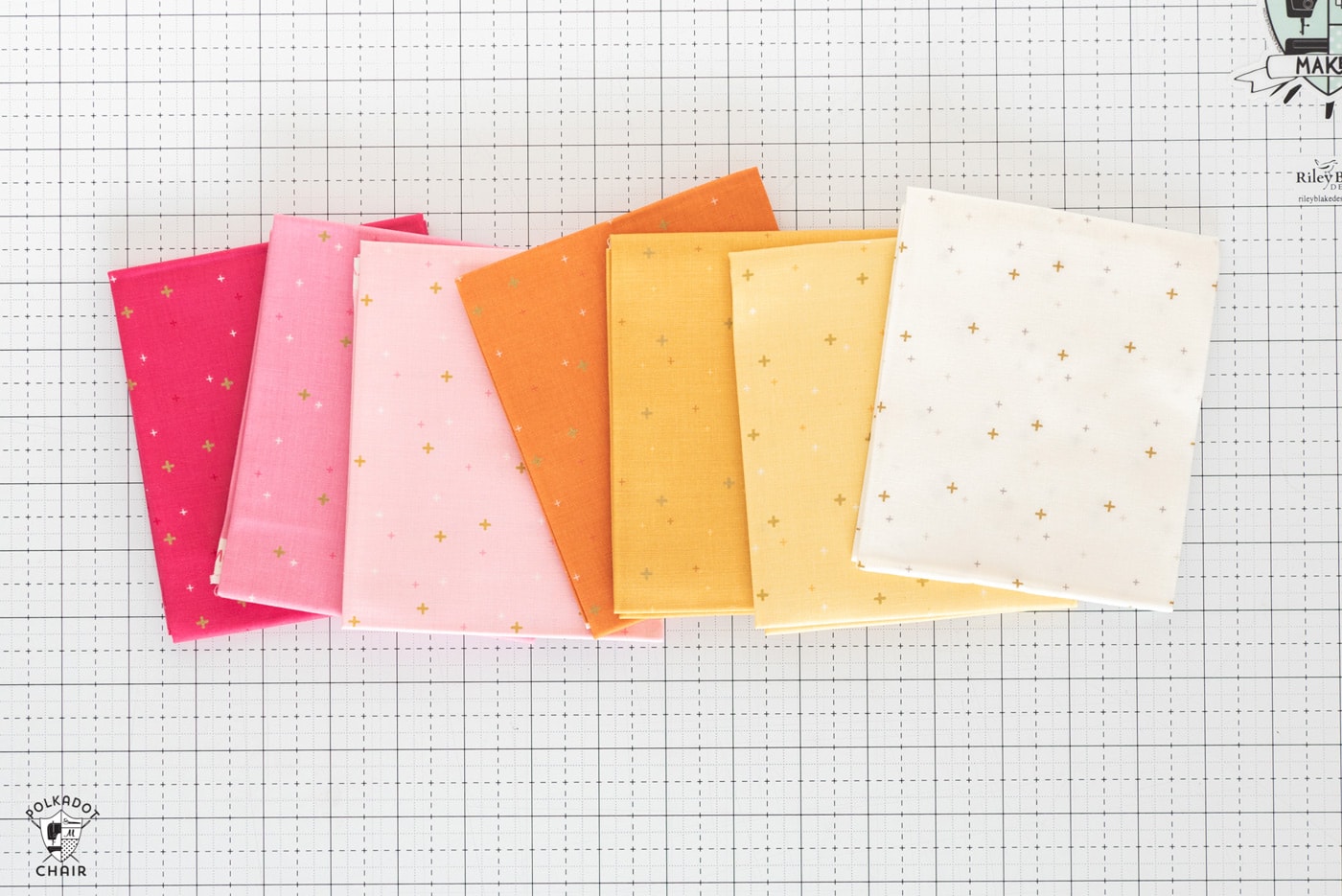 stack of colorful folded fabrics on white cutting mat