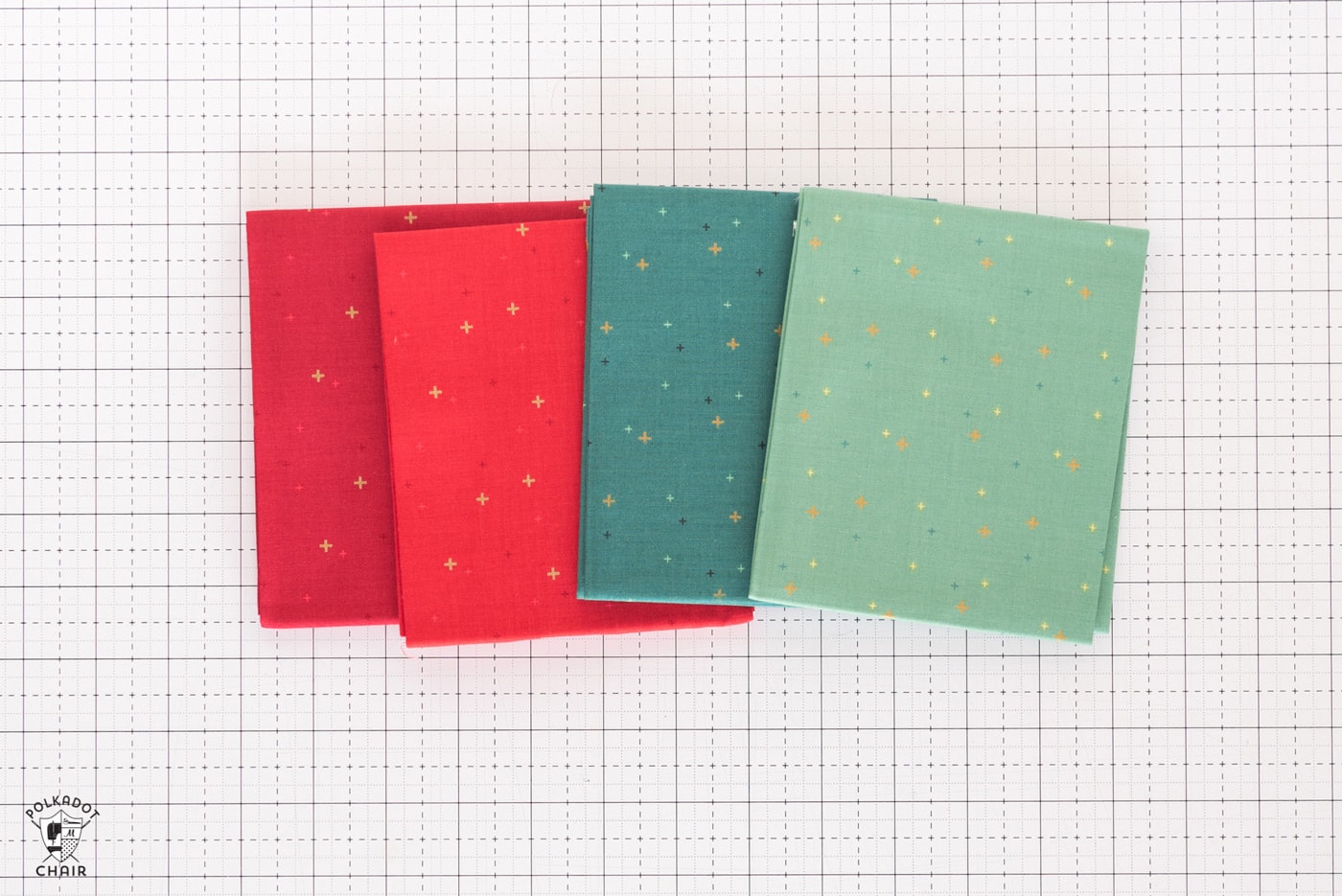 stack of colorful folded fabrics on white cutting mat