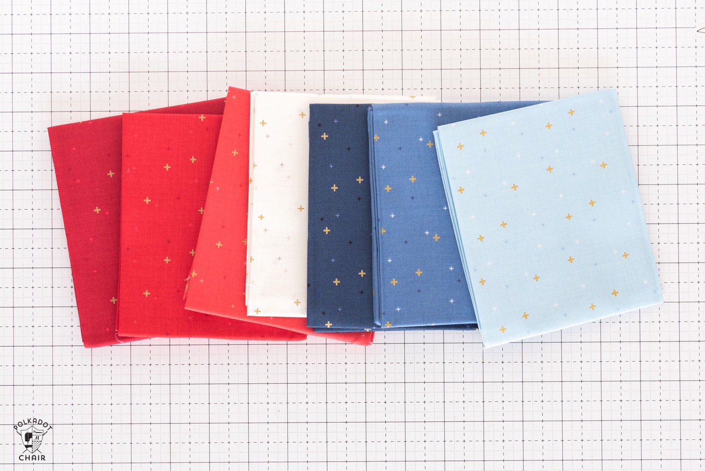stack of colorful folded fabrics on white cutting mat