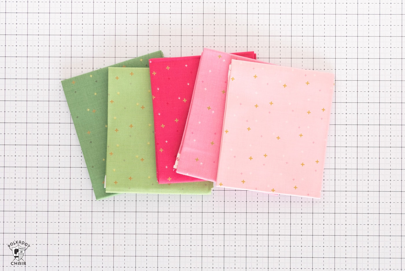 stack of colorful folded fabrics on white cutting mat