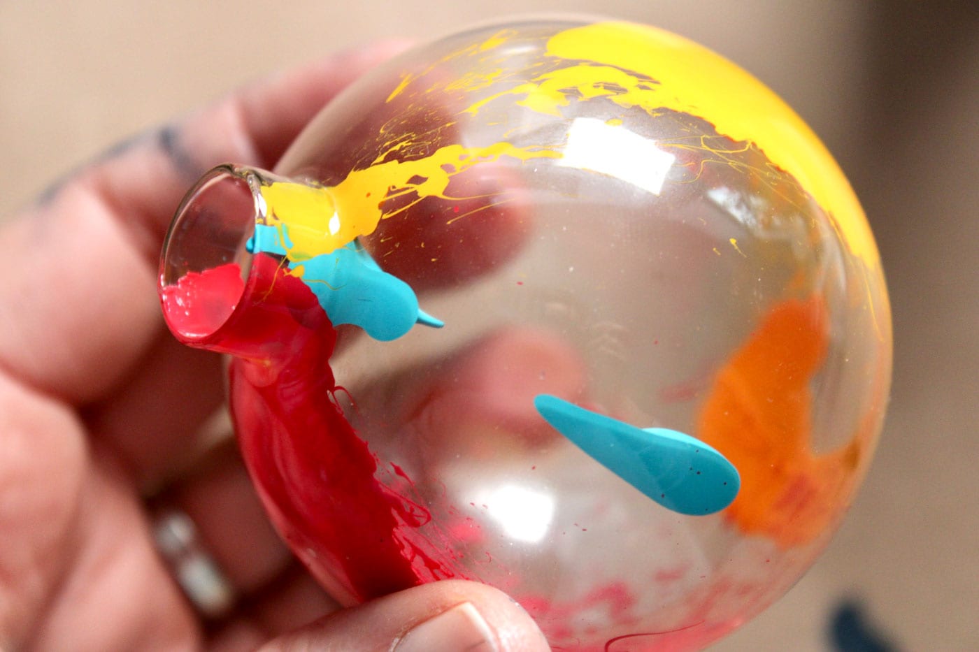 close up of paint inside of glass ornament showing dollop of turquoise paint