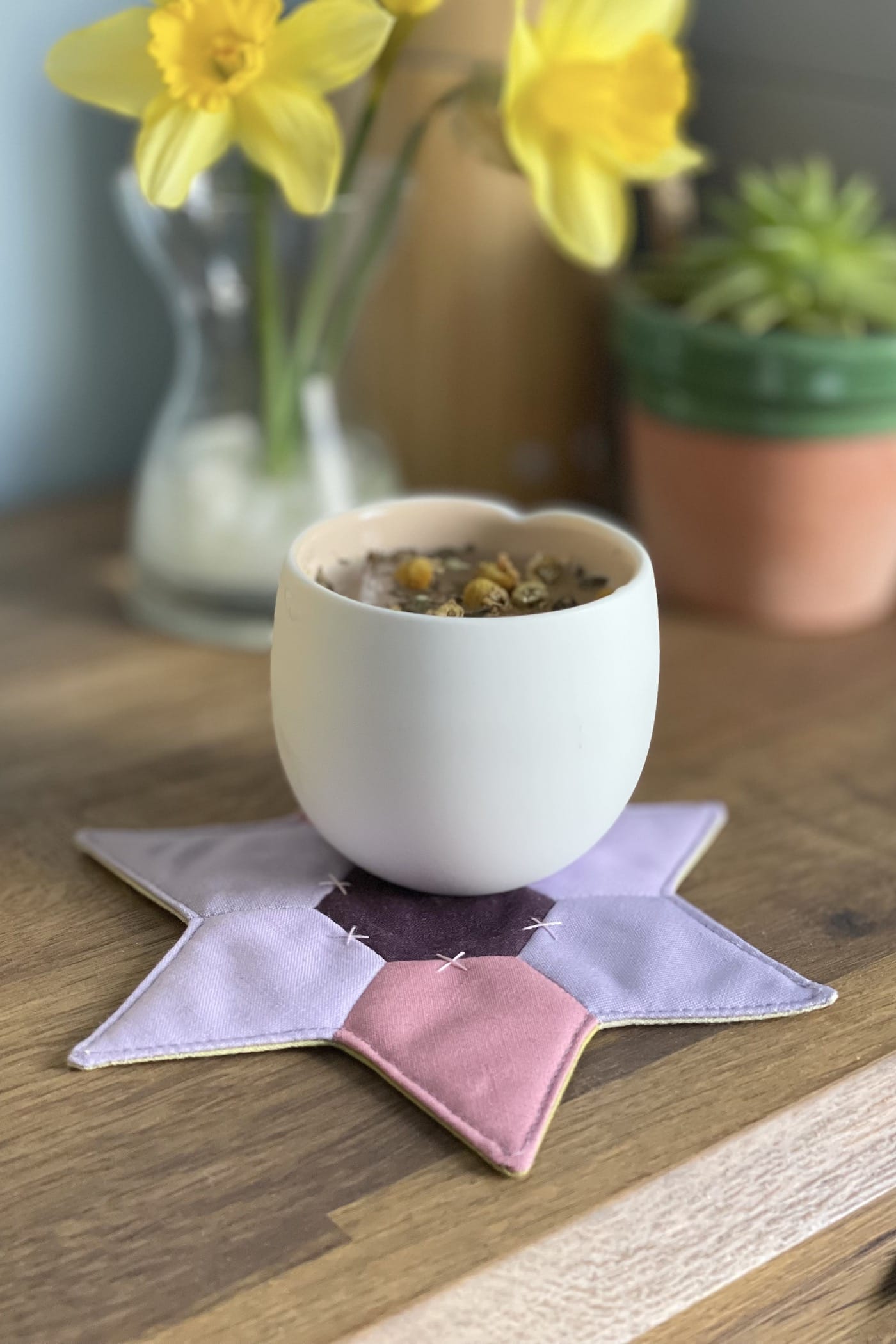 star shaped mug rug with flowers and cup on wood table