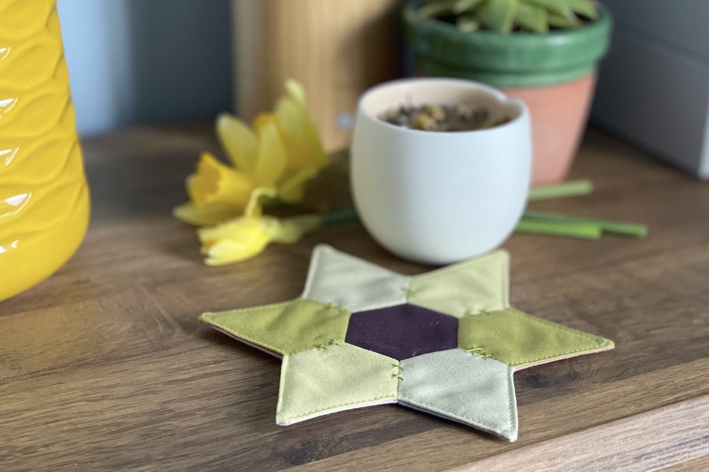 star shaped mug rug with flowers and cup on wood table