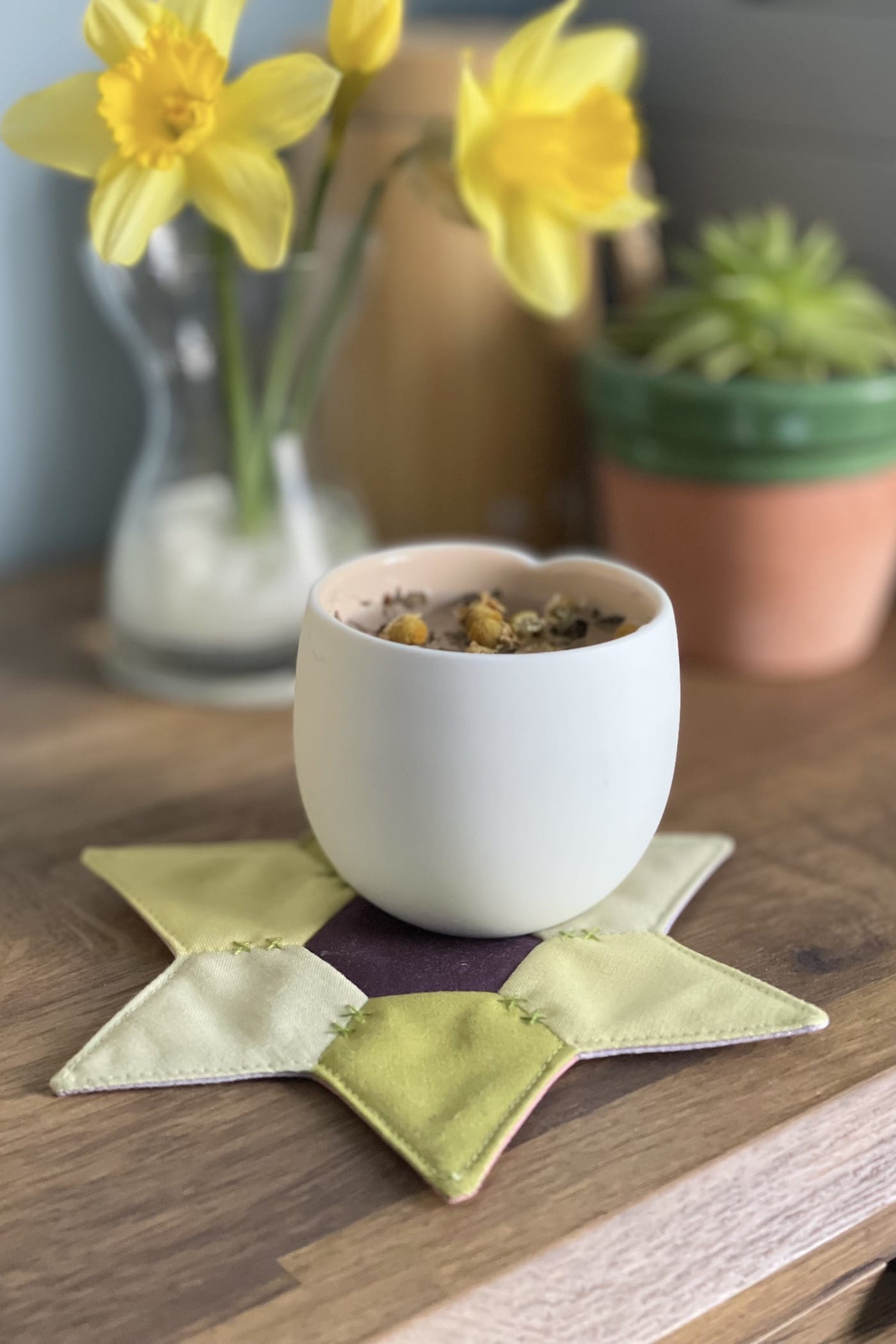 star shaped mug rug with flowers and cup on wood table