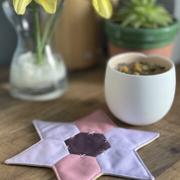 star shaped mug rug with flowers and cup on wood table