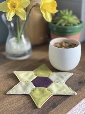 star shaped mug rug with flowers and cup on wood table