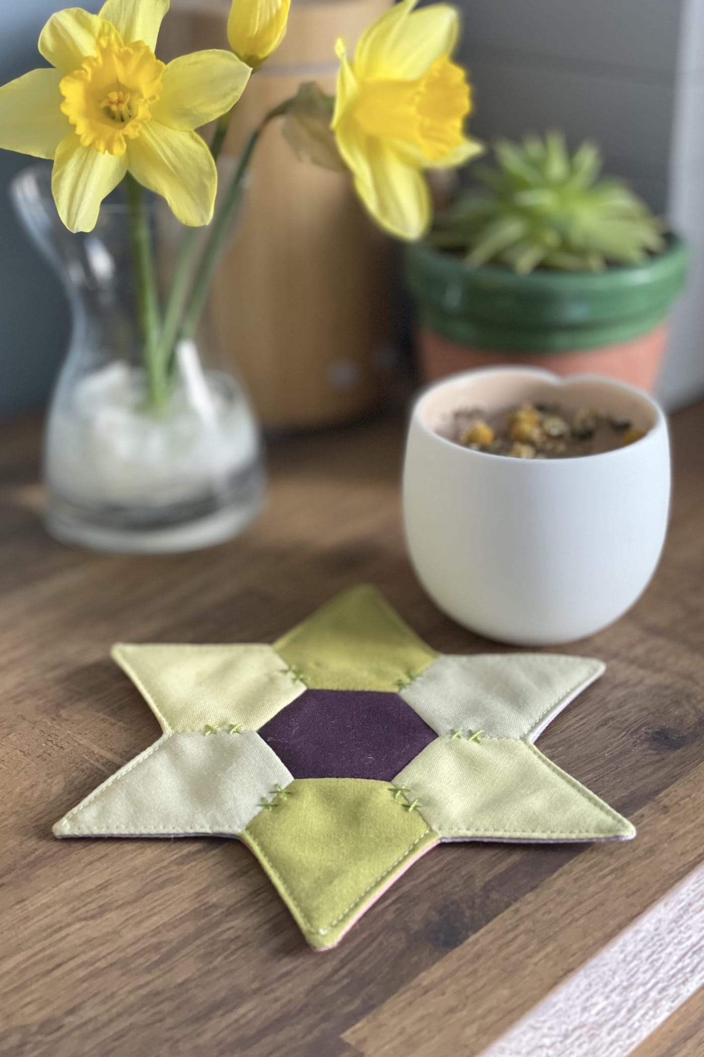 star shaped mug rug with flowers and cup on wood table