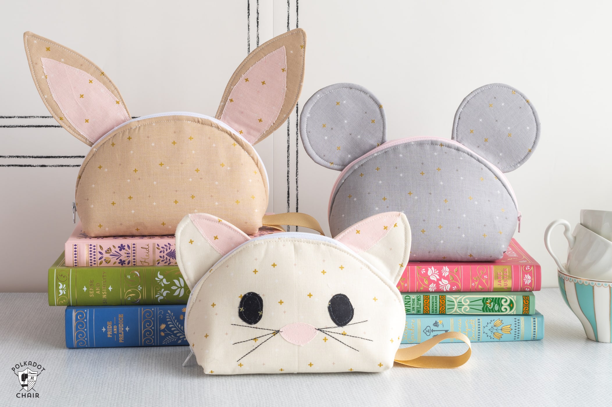 bunny, cat and mouse neutral color zip pouches on table with books