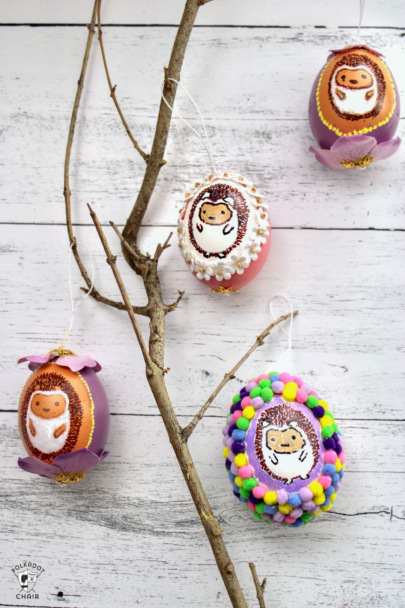 multiple blown egg ornaments with painted hedgehogs on white wood table