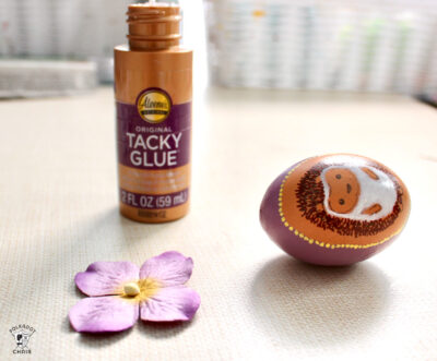 tacky glue, egg and flower on table