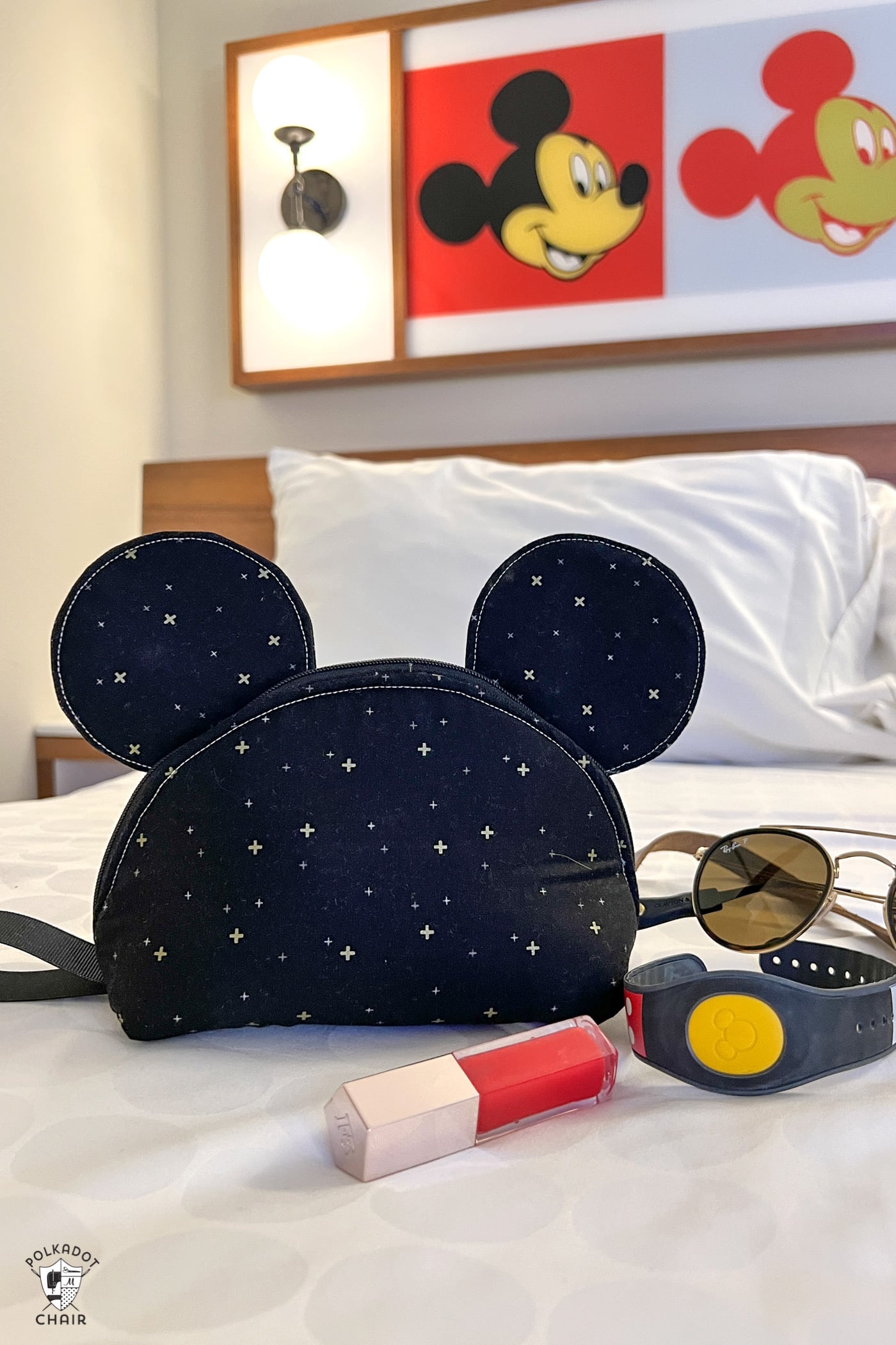 black mouse zip bag on bed in front of mickey mouse art